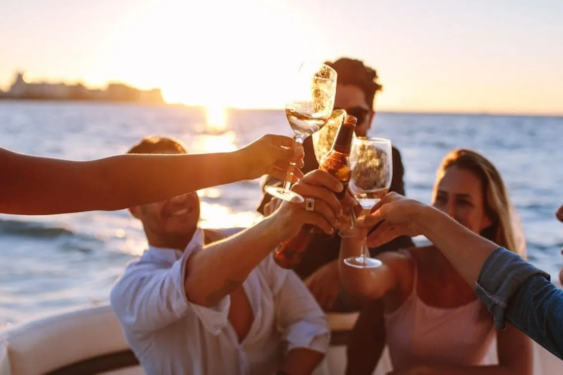Přátelé při západu slunce s aperitivem na lodi